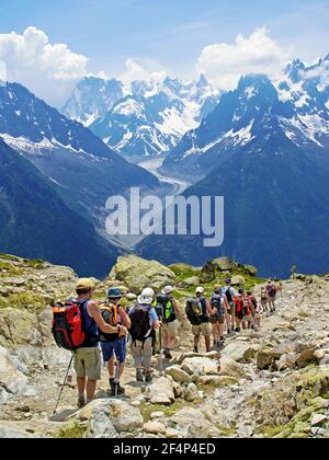 Escursionisti su un sentiero di alta montagna ai piedi del massiccio del Monte Bianco. Foto Stock