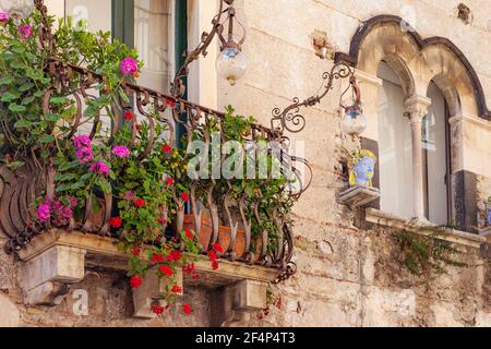 Fiori su una finestra balcone su una casa a Taormina, Sicilia, Italia Foto Stock
