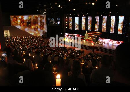 Persone azienda illuminato candele durante la Messa di Natale a Thomas Road Baptist Church di Lynchburg, VA, Stati Uniti d'America Foto Stock