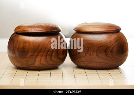 Goban, Baduk, Weiqi o Maklom - gioco da tavolo di strategia asiatica tradizionale. Pietra bianca e nera del gioco da tavolo cinese Foto Stock