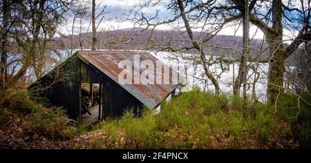 Una vecchia boathouse sulla riva di Loch Achilty a Ross-shire. Foto Stock