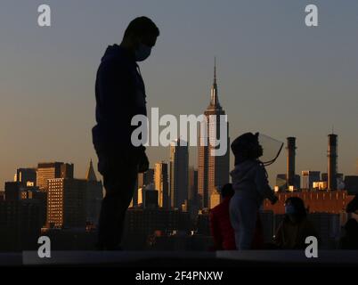 Brooklyn, Stati Uniti. 22 marzo 2021. Un bambino indossa uno scudo protettivo del coronavirus mentre gioca su un'installazione d'arte di piattaforme incandescenti intitolate "Reflect" in Domino Park a New York City lunedì 22 marzo 2021. Foto di John Angelillo/UPI Credit: UPI/Alamy Live News Foto Stock