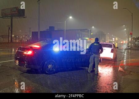 La polizia ferma un'auto in una notte piovosa a Detroit, Michigan, USA Foto Stock