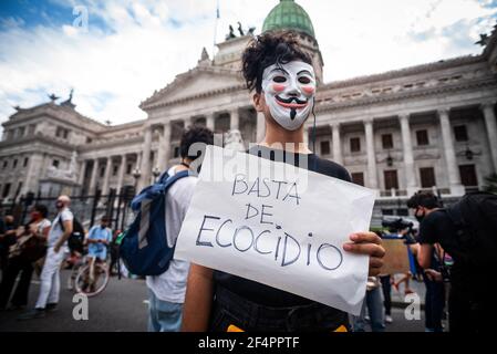 Buenos Aires, Argentina. 22 marzo 2021. Un protester che indossa una maschera tiene un cartello che dice abbastanza di ecocida durante la dimostrazione. Diverse organizzazioni ambientaliste hanno effettuato una mobilitazione per sensibilizzare i cittadini sui cambiamenti climatici nella giornata mondiale dell'acqua. (Foto di Alejo Manuel Avila/SOPA Images/Sipa USA) Credit: Sipa USA/Alamy Live News Foto Stock