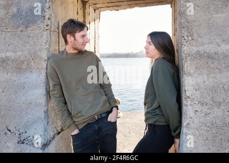 Bell'uomo con le orecchie e attraente giovane donna in amore. Avere romantico. Amanti che si pongono contro il muro. Trascorrere il tempo insieme. Concetto persone reali Foto Stock