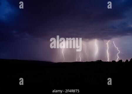 Pericoloso temporale fulmine sul cielo notturno in un villaggio campo in estate Foto Stock