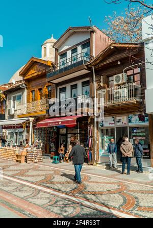 Edirne, Turchia - 26 febbraio 2021 - Fotografia di strada delle persone a piedi e tradizionali case di legno con negozi nel centro di Edirne, Turchia occidentale. Foto Stock