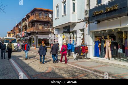 Edirne, Turchia - 26 febbraio 2021 - Fotografia di strada delle persone a piedi e tradizionali case di legno con negozi nel centro di Edirne, Turchia occidentale. Foto Stock