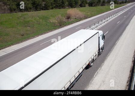 Spostamento di un carrello ad alta velocità sull'autostrada di campagna in una giornata intensa Foto Stock