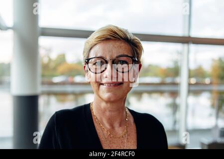 Ritratto di bella donna d'affari matura in ufficio. Caucasica donna professionale aziendale guardando la fotocamera con sicurezza. Foto Stock