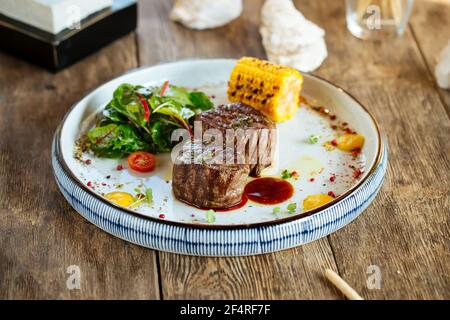 Bistecche di filetto mignon alla griglia con mais e insalata Foto Stock