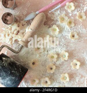 Fiori di marzapane bianchi preparati per la decorazione di torte con attrezzi fondenti e tagliabiscotti. Foto Stock