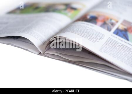 Apri la rivista con foto a colori e testo non letto con Narrow profondità di campo ad un angolo rispetto allo sfondo bianco isolato Foto Stock