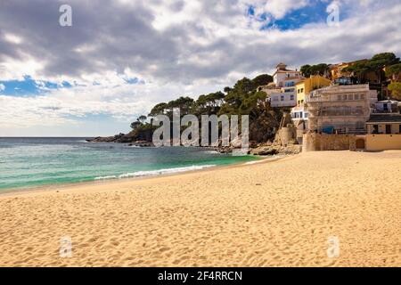 Vista della costa sud della spiaggia di Llafranc in una giornata di primavera, quando il sole vi invita già a riposarvi sulla sua sabbia. Palafrugell, Catalogna, Spagna Foto Stock