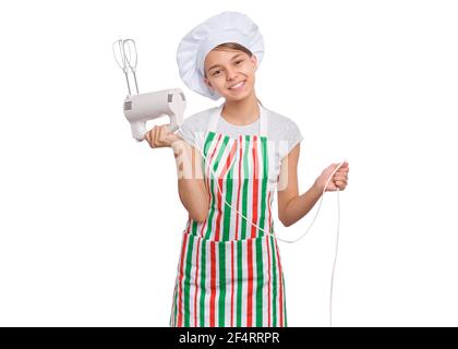 Teen girl in cappello chef in grembiule con frusta d'uovo, isolato su sfondo bianco. Foto Stock