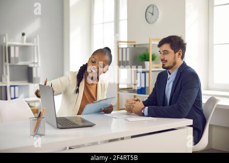 Giovane uomo incontro con agente immobiliare professionale, manager bancario o consulente di prestito Foto Stock