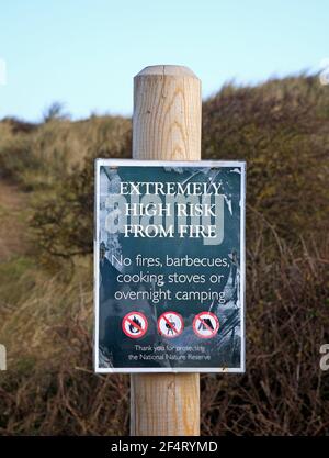 Un segno plastificato di avvertimento di rischio estremamente elevato di incendio sulla Riserva Naturale Nazionale di Holkham a Burnham Overy, Norfolk, Inghilterra, Regno Unito. Foto Stock