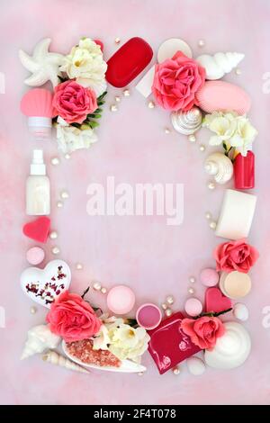 Prodotti naturali per trattamenti di bellezza con fiori di rosa e freesia e conchiglie e perle decorative. Su sfondo di marmo rosa. Vista dall'alto. Foto Stock