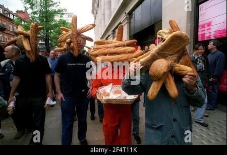 Japanease artista Tatsumi Origoto maggio 2001, conduce una sfilata di persone con pani di pane lungo Oxford Street, fuori Selfridges per coincidere con la vita di Tokyo. Tatsumi Origoto è sulla destra. Foto Stock