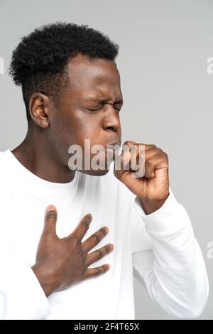 L'uomo nero tosse, ha sofferto di asma, influenza, allergia, bronchite, tubercolosi, toccandola il petto Foto Stock