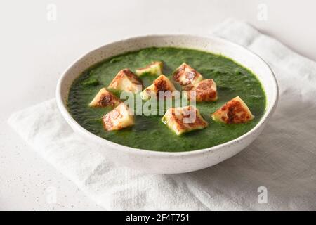 Cucina vegetariana indiana Palak Paneer di spinaci e formaggio paneer su sfondo bianco. Primo piano. Foto Stock