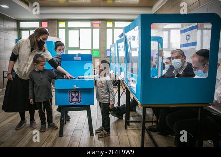 Gerusalemme, Israele. 23 marzo 2021. I membri di una famiglia ebrea ortodossa hanno votato all'interno di un scrutinio presso una stazione elettorale durante le elezioni parlamentari israeliane. Credit: Noam Moskowitz/dpa/Alamy Live News Foto Stock