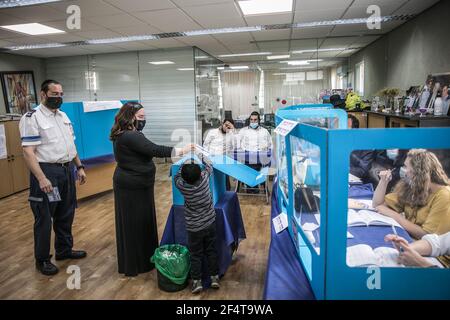 Gerusalemme, Israele. 23 marzo 2021. Una donna ebrea ultra-ortodossa lancia il suo voto all'interno di una casella elettorale in una stazione elettorale durante le elezioni parlamentari israeliane. Credit: Noam Moskowitz/dpa/Alamy Live News Foto Stock