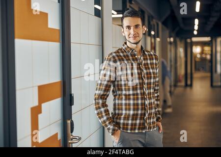 Calmo giovane in piedi nel corridoio Foto Stock