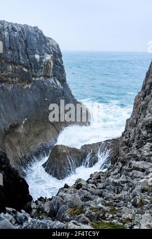 Onde che si infrangono contro le scogliere calcaree carsiche delle Asturie, Costa di Llanes, Spagna Foto Stock