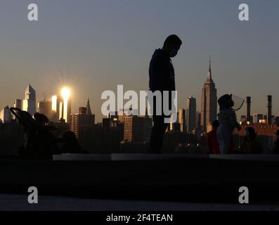 Brooklyn, Stati Uniti. 23 marzo 2021. Un bambino indossa uno scudo protettivo del coronavirus mentre gioca su un'installazione d'arte di piattaforme incandescenti intitolate "Reflect" in Domino Park a New York City lunedì 22 marzo 2021. Foto di John Angelillo/UPI Credit: UPI/Alamy Live News Foto Stock