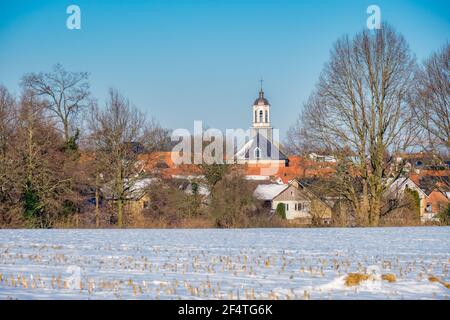 Paesaggio invernale olandese in cui si può vedere il villaggio di Ootmarsum e la sua Chiesa Riformata. Si trova nella parte orientale dei Paesi Bassi Foto Stock