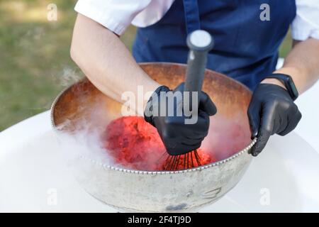 Primo piano di una gelatiera che prepara una bacca e un panna. Estate Foto Stock