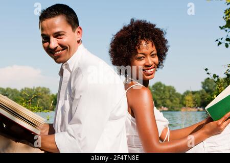 Donna fa stretching esterno con il suo personal trainer su un grande giorno d'estate Foto Stock