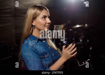 Cantante femminile che canta una canzone. Donna che si esibisce in una registrazione st Foto Stock