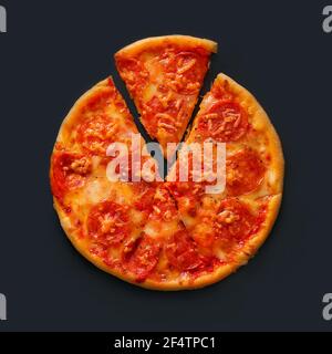 Vista dall'alto di una deliziosa pizza piccante con formaggio e salsicce, che si trova su uno sfondo scuro e una fetta di pizza si trova tagliata accanto Foto Stock