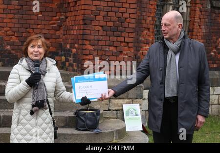 23 marzo 2021, Turingia, Gera: Wolfgang Tiefensee (r) (SPD), ministro dell'Economia in Turingia consegna un denaro della lotteria di 10.000 euro a Gitta Heil, curatrice della Biennale di Höhler, durante la campagna di piantagione di alberi in onore della X Biennale di Höhler. Foto: Bodo Schackow/dpa-Zentralbild/dpa Foto Stock