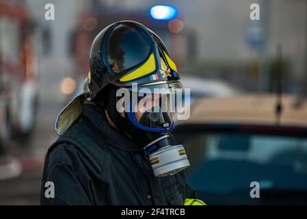 Primo piano del pompiere con maschera a gas durante i lavori di emergenza Foto Stock