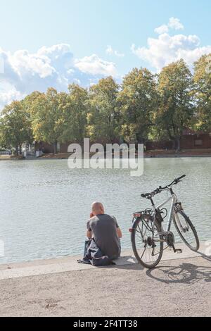 Bellissimo Parco Hiroshima-Nagasaki durante la primavera, vista sul lago con un uomo in bicicletta, Colonia, Germania Foto Stock