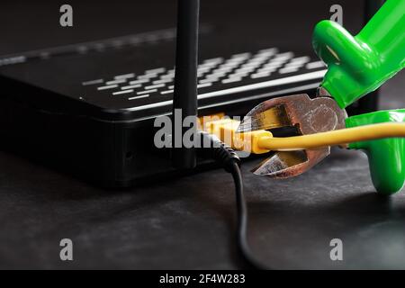 Rompere e tagliare i pezzi verdi della connessione di rete del filo giallo della connessione Internet. Disattivazione e limitazione dell'accesso a Internet Foto Stock