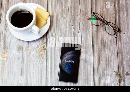 Un telefono cellulare o un telefono cellulare posato su un legno Tavolo con l'app Skywiki aperta sullo schermo Foto Stock