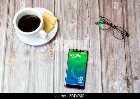 Un telefono cellulare o un telefono cellulare posato su un legno Tabella con l'app NADRA aperta sullo schermo Foto Stock