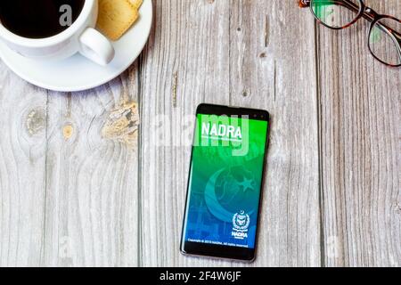 Un telefono cellulare o un telefono cellulare posato su un legno Tabella con l'app NADRA aperta sullo schermo Foto Stock