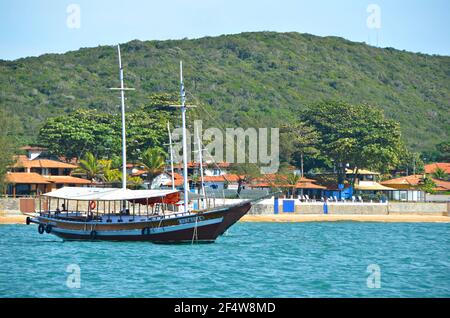 Paesaggio con vista di un tradizionale giro turistico Schooner sulle acque di Armação dos Búzios, la rinomata località turistica di Rio de Janeiro, Brasile. Foto Stock