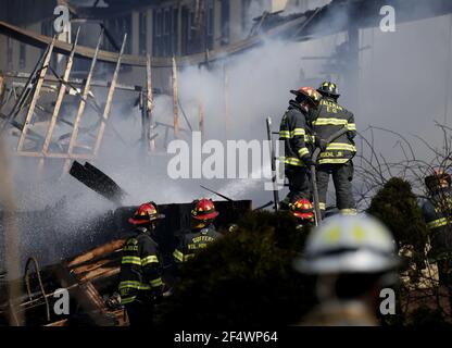 New York, Stati Uniti. 23 marzo 2021. I vigili del fuoco continuano a colpire le aree di smoldering con acqua da un tubo antincendio e setacciare attraverso le macerie con un bulldozer dopo un incendio scoppiato a Evergreen Court Home for Adults in Spring Valley, New York martedì 23 marzo 2021. Il massiccio incendio del New York Assisted-living Facility Martedì ha lasciato un residente morti e altri feriti. Foto di John Angelillo/UPI Credit: UPI/Alamy Live News Foto Stock