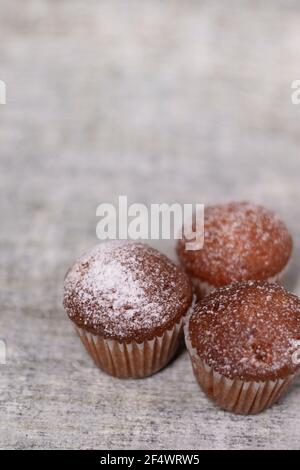 tre tortine di muffin ricoperte di zucchero in polvere. panetteria dolce Foto Stock