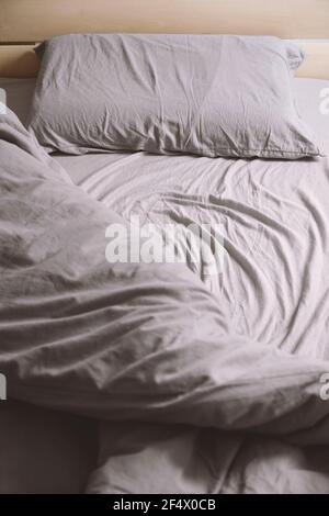 letto vuoto non fatto con biancheria da letto o da letto sgualcita Foto Stock