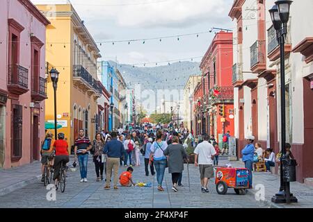 Messicani a piedi nella zona pedonale con negozi colorati nel centro storico coloniale della città di Oaxaca, Messico sud-occidentale Foto Stock