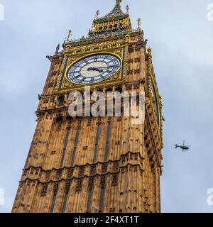 La famosa torre dell'orologio Big ben con un elicottero sullo sfondo a Londra in Inghilterra, Regno Unito Foto Stock