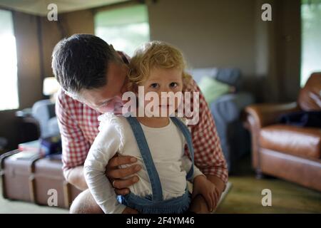 Ritratto affettuoso padre abbracciando la figlia del toddler Foto Stock