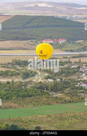 Russia, Crimea, Belogorsk 19 settembre 2020-UN pallone giallo GelbeSeiten vola sui giardini del villaggio di Belaya Skala ai piedi del mou Foto Stock